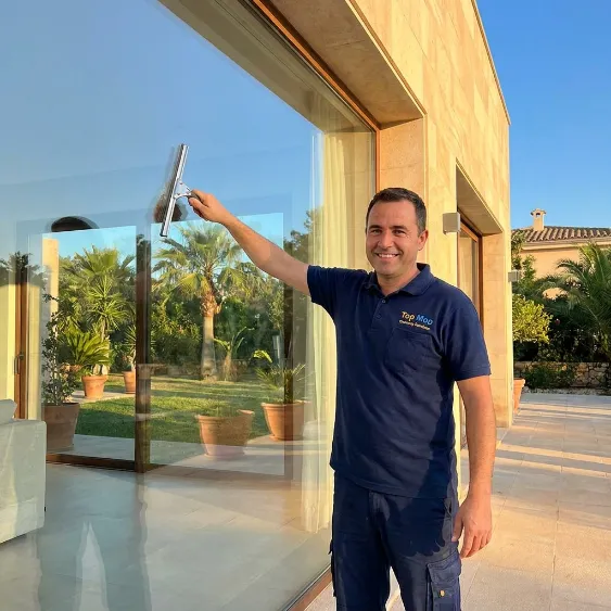 Professional window cleaner cleaning high-rise balcony glass in Dubai