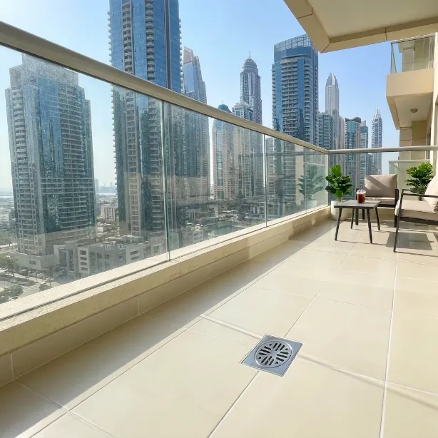 Clean apartment balcony with glass railing and Dubai skyline view