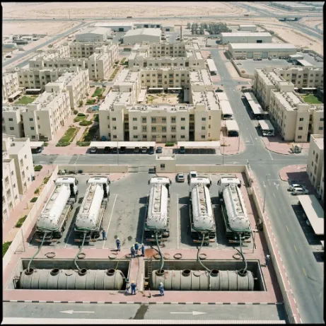 Multiple vacuum tanker trucks cleaning underground septic tanks at an industrial facility in Dubai